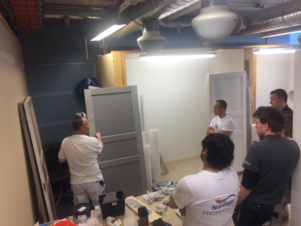 Per demonstrerer dørmaling for elever