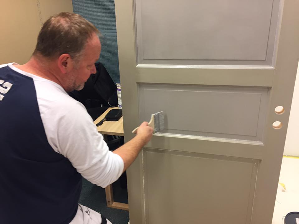 Nærbilde av Per som maler en dør med pensel